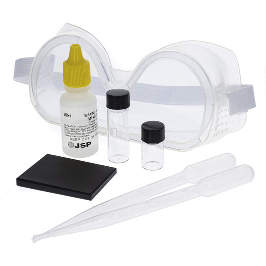 Seven-piece gold testing kit with tools arranged on a plain background